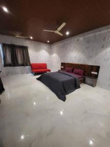 a bedroom with a bed and two red chairs at Imagine Harmony in Lonavala