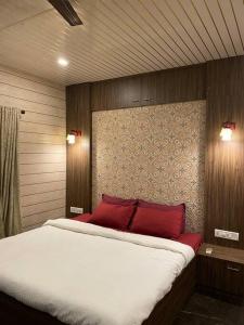 a bedroom with a large bed with red pillows at Imagine Harmony in Lonavala