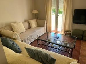 a living room with a couch and a glass coffee table at Villa America in Roche