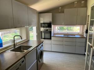 a kitchen with white cabinets and a sink at Villa America in Roche
