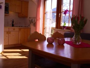 een keuken met een houten tafel en een vaas met bloemen erop bij Ferienwohnung Gsenger - b53283 in Abtenau