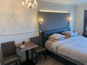 um quarto com uma cama, uma mesa e um lustre em C view Casino em Middelkerke