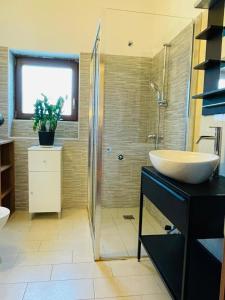 y baño con lavabo y ducha. en Ferienwohnung für 4 Personen ca 90 qm in Duino-Aurisina, Adriaküste Italien Küste von Friaul-Julisch Venetien, en Duino