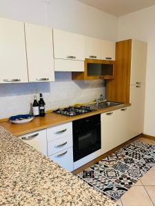 cocina con armarios blancos y fogones en Ferienwohnung für 4 Personen ca 90 qm in Duino-Aurisina, Adriaküste Italien Küste von Friaul-Julisch Venetien, en Duino