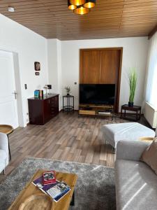 ein Wohnzimmer mit einem Sofa und einem TV in der Unterkunft Auguststadt-Residenz in Wolfenbüttel