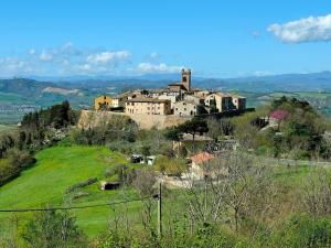 un villaggio in cima a una collina con un castello di B&B Locanda Montefabbri a Monte Fabbri