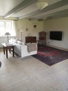 a living room with a white couch and a flat screen tv at Foxhouse in Præstø