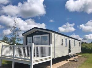 a mobile home with a porch and a cloudy sky at Platinum caravan holidays in Port Seton