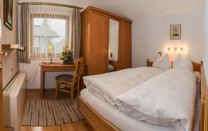 una camera con letto, scrivania e finestra di KREUZHOF Seefeld a Seefeld in Tirol
