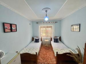 a room with two beds and a window at Guest House Dimos Kristi in Përmet