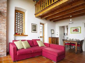 ein Wohnzimmer mit einem roten Sofa und einem Tisch in der Unterkunft Ferienwohnung für 4 Personen ca 65 m in Pisano, Piemont Lago Maggiore in Pisano