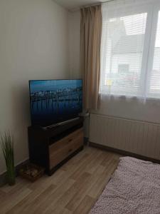 - un salon avec une commode et une télévision à écran plat dans l'établissement APARTMAN OLOMOUC 2KK, à Olomouc