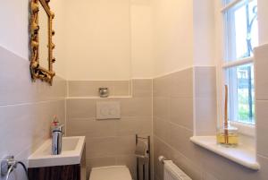 Un baño con inodoro, lavabo y ventana. en Ferienhaus in Garmisch-Partenkirchen, en Garmisch-Partenkirchen