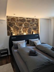 2 camas en una habitación con una pared de piedra en Ferienwohnung Zum Kühlen Grund, en Eimelrod