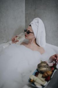 une femme dans une baignoire avec une serviette sur la tête dans l'établissement Holiday Inn Lübeck, an IHG Hotel, à Lübeck