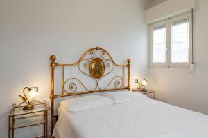 - une chambre dotée d'un lit blanc avec un cadre doré dans l'établissement Ca' Graziosi Fiori, à Bagnone
