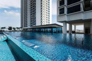 une grande piscine à côté d'un grand bâtiment dans l'établissement Lovely Studio Trefoil Near Setia City Mall & SCCC, à Shah Alam