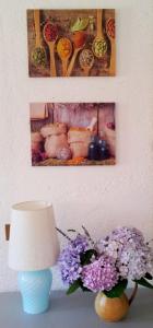 una mesa con una lámpara y flores y fotografías púrpuras en Appartement in Barano d Ischia mit schöner Terrasse, en Isquia