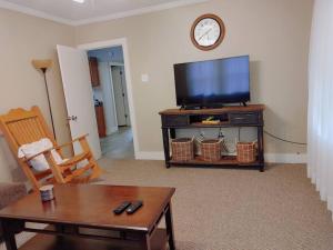 a living room with a flat screen tv and a table at Quiet Country Small Family Home 5 minutes from town in Mansura