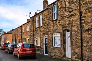 a row of brick houses on a street at Finest Retreats - Byron Street in Amble