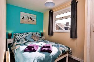 a bedroom with a bed with towels on it at Finest Retreats - Byron Street in Amble