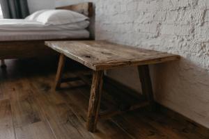 uma mesa de madeira num quarto com uma cama em Hotel Dynasty em Kamianets-Podilskyi