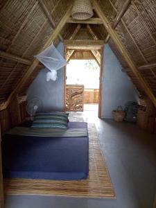 a bedroom with a blue bed in a attic at Balay Asiano Cabin in Puerto Princesa City