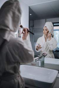 una mujer cepillándose el pelo delante de un espejo en Holiday Inn Lübeck, an IHG Hotel en Lübeck