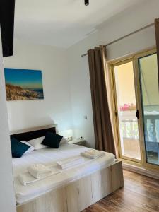 um quarto com uma cama e uma grande janela em Villa Kanto (Holiday apartments and rooms) em Vlorë