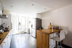a kitchen with a wooden counter and a refrigerator at Veeve - Chic By Bonne-Nouvelle in Paris
