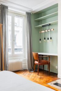 a bedroom with a desk and a chair next to a window at Veeve - Chic By Bonne-Nouvelle in Paris