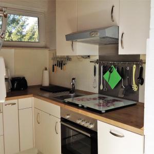 a kitchen with a sink and a stove at Bungalow 5566 in Tossens in Butjadingen OT Tossens