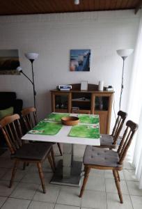 a dining room table with chairs and a table with a bowl on it at Bungalow 5566 in Tossens in Butjadingen OT Tossens