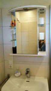 a bathroom with a sink and a mirror at Bungalow 5566 in Tossens in Butjadingen OT Tossens