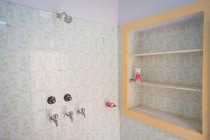 a bathroom with a shower with two sinks and a shelf at Chopasani Room in Jodhpur
