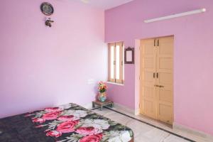 a bedroom with pink walls and a bed with flowers on it at Chopasani Room in Jodhpur