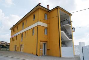 un edificio amarillo con balcones en un lateral en Ferienwohnung für 4 Personen ca 45 qm in Offida, Adriaküste Italien Küste der Marken, en Offida