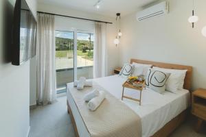 a bedroom with two beds and a large window at Aiolia Villa in Lachania +36 photos