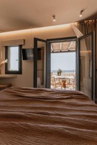 a bedroom with a bed with a view of the ocean at ONYM Curated Villas in Plaka