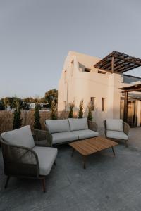 a patio with couches and tables and a building at ONYM Curated Villas in Plaka