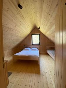 1 dormitorio con 1 cama en una habitación de madera en Domki nad Kukówkiem, en Wdzydze Tucholskie