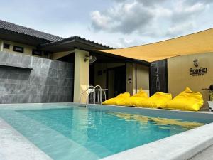 a hotel with a swimming pool with yellow inflatable pillows at Morimei Khaoyai in Ban Khlong Yang