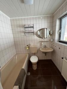 La salle de bains est pourvue d'une baignoire, de toilettes et d'un lavabo. dans l'établissement Club Villa, à Ramsau am Dachstein