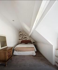 a attic bedroom with a bed and a table at Maison de paludier dans hameau de charme in Guérande