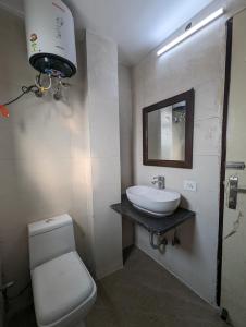 a bathroom with a white toilet and a sink at Hotel Aron By The Premium Villa in New Delhi