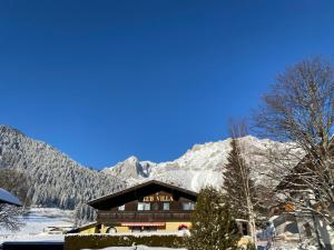 a ski lodge with snow covered mountains in the background at Club Villa in Ramsau am Dachstein