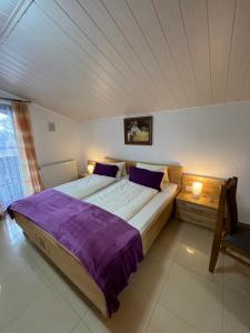a bedroom with a large bed with purple sheets at Club Villa in Ramsau am Dachstein