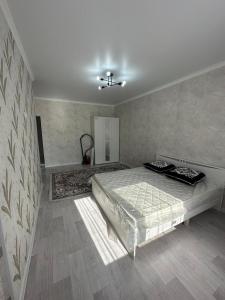 a bedroom with a bed and a ceiling at Квартира in Aktau