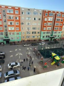 een groep mensen die rondlopen op een parkeerplaats met auto's bij Квартира in Aqtau