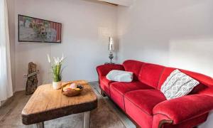 a red couch in a living room with a table at Heimathafen - a27537 in Ueckeritz
